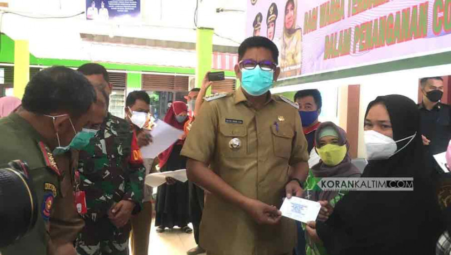 Penyaluran BLT secara simbolis yang diberikan langsung oleh Basri Rase ke salah satu warga, di Aula Kelurahan Api-Api, Kecamatan Bontang Utara. ( Foto: Dok.Korankaltim)