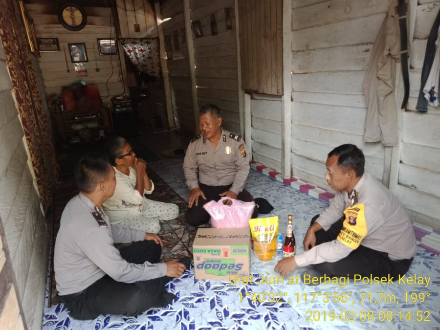 JUMAT BERBAGI - Kapolsek Kelay Iptu Dutrisno (tengah) bersama Bhabinkamtibmas menyerahkan bantuan kepada Marta, warga Kelay. (Indra/KoranKaltim.Com)