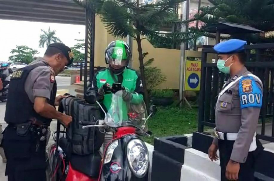 Petugas saat melakukan pemeriksaan di pintu gerbang, terhadap ojol yang mengantarkan pesanan di Mapolresta Samarinda pada Rabu (13/11) tadi. (Foto: Nancy/korankaltimcom)