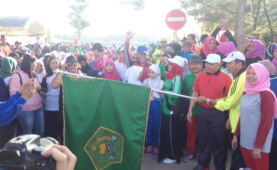 Asisten Umum Setkab Kukar, Heldiansyah mengibarkan bendera start pertanda dimulainya jalan santai kerukunan pada Sabtu (5/1/2019)