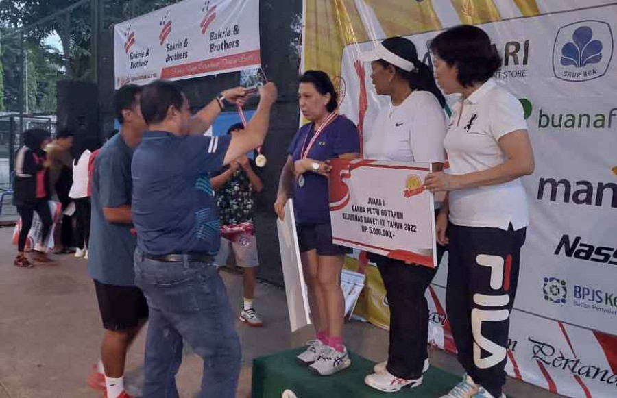 Ketua Baveti Kaltim H Zairin Zain saat mengalungkan medali kepada petenis veteran Kaltim yang meraih medali perak. (ist)