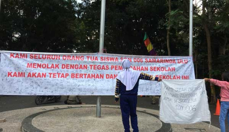 Spanduk penolakan pemindahan sekolah terpajang di depan balaikota
