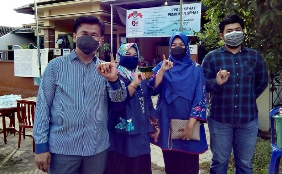 Sekda Kukar Sunggono bersama Keluarga yang Menunjukkan Jari Kelingking bertinta Sebagai Bukti Telah Memberikan Hak Pilihnya (Foto: heri/korankaltim.com)