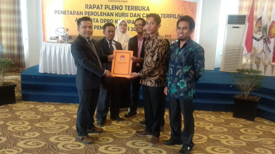 Ketua KPU Paser Abdul Qayyim Rasyid menyerahkan salinan hasil pleno kepada salah satu saksi partai politik. (Dwi Cahyo/KoranKaltim.Com)