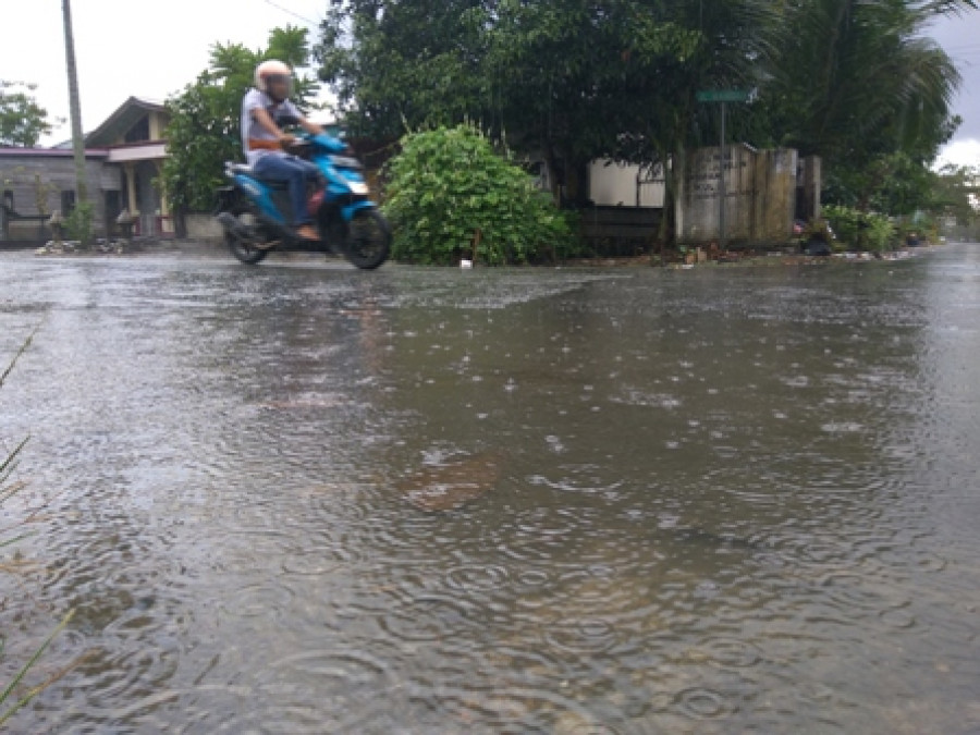 HUJAN: Salah seorang pengguna jalan melintas saat hujan kemarin. BMKG Memprediksi awal tahun tetap diguyur hujan.