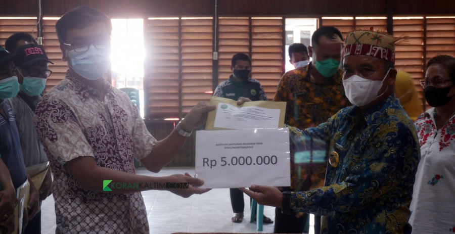 Penyerahan bantuan uang tunai oleh Wabup secara simbolis kepada perwakilan korban kebakaran (Foto: Yosafat/korankaltim.com)