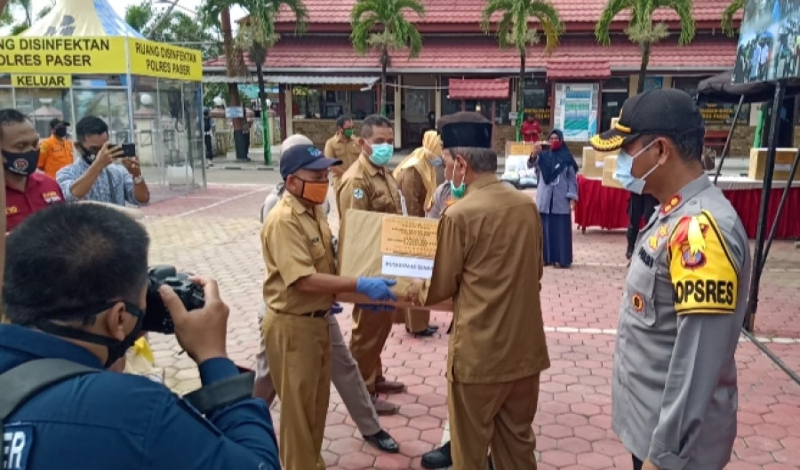 Wakil Bupati Paser Kaharuddin menyerahkan bantuan APD Polres Paser kepada tenaga medis. (Foto: Dwi Cahyo/KoranKaltim.Com)