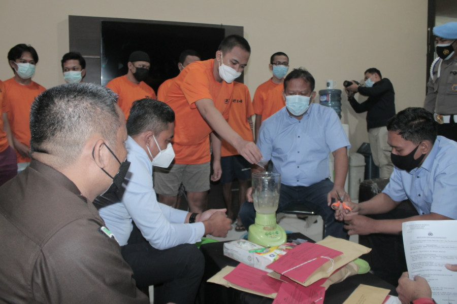 Salah satu tersangka saat menuangkan sabu-sabu ke dalam blender untuk dimusnahkan Selasa (4/5/2021) hari ini. (Foto:Nancy/korankaltim.com)