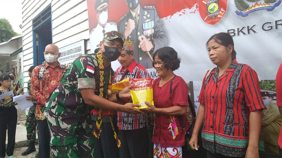 Dansatgas TMMD ke-113 wiltas Kabupaten Kubar, Letkol Kav Yudhi Prasetyo Purnomo saat membagikan minyak goreng secara simbolis kepada warga Kampung Kelian. (Handayan/korankaltim.com)