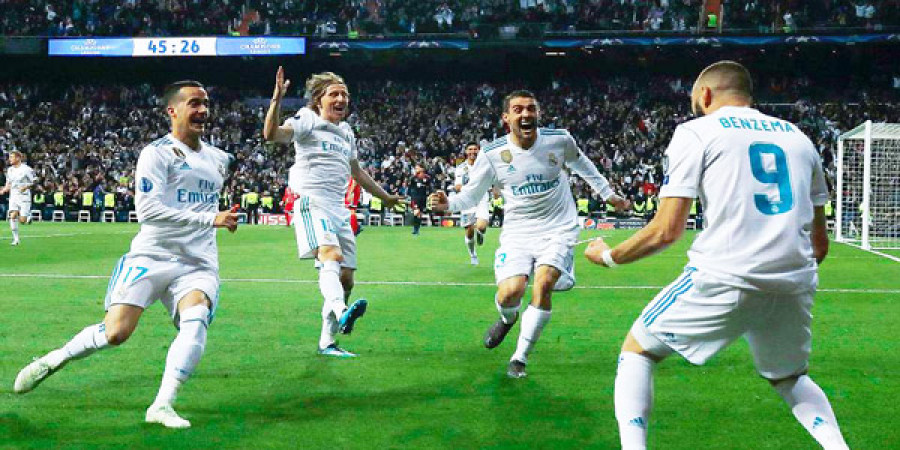 PAHLAWAN KELOLOSAN : Mencetak dua gol ke gawang Bayern Munchen, Karim Benzema (kanan) disambut pemain-pemain Real Madrid. (dailymail)