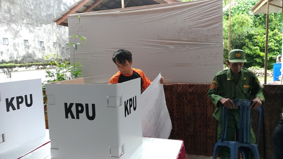 Petugas KPPS dan Linmas sedang mempersiapkan logistik Pilgub Kaltim di TPS. Pelaksanaan hari pencoblosan diprediksi BMKG diwarnai hujan berintensitas ringan hingga lebat di beberapa wilayah Kaltim.