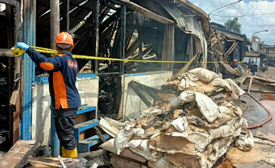 Relawan Infis Polresta Samarinda saat memasang garis polisi disekitar lokasi terbakar Kamis (5/8/2021) hari ini. (Foto:Nancy/korankaltim.com)