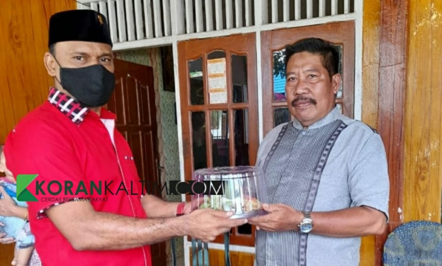 Ketua DPC PDIP Kabuapten Paser Muhammad Saleh saat menyerahkan tumpeng kepada seorang tokoh masyarakat. (foto: Dwi Cahyo / Korankaltim.com)