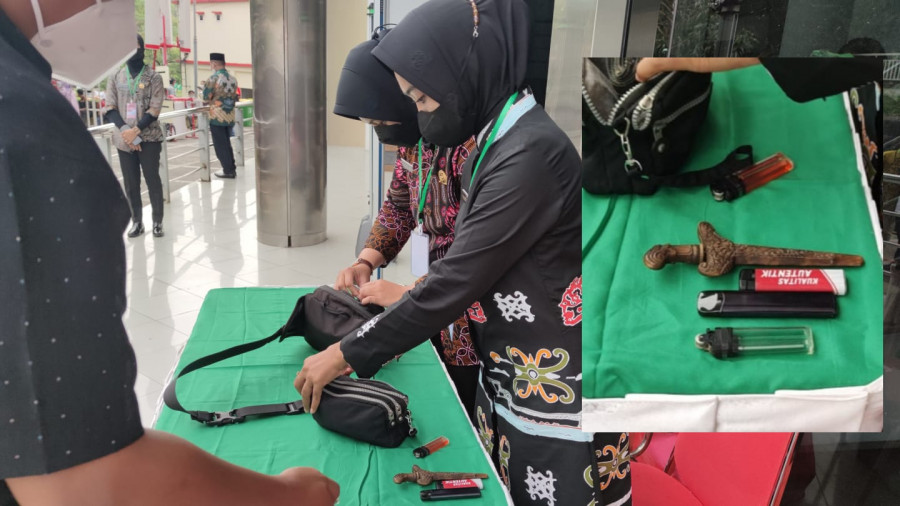 Petugas Pas Pampres saat mengamankan barang bukti pisau cutter dan keris di pintu masuk gedung Dome Balikpapan. (Yudi Hadi)
