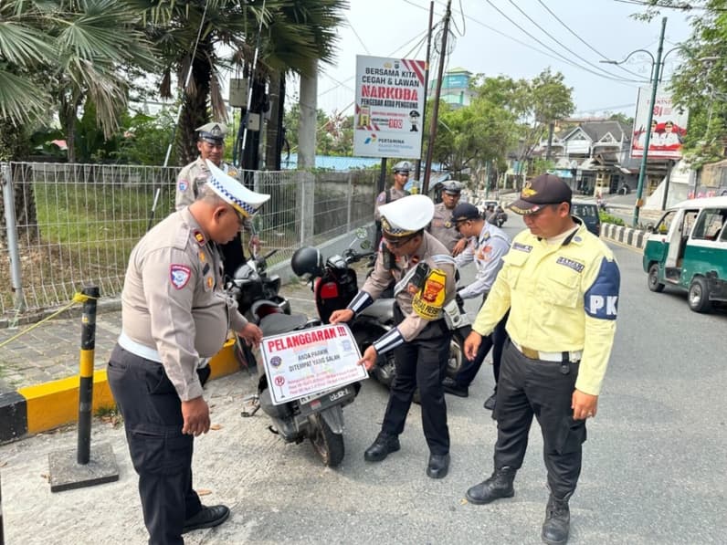 Polisi menempelkan stiker terhadap motor yang parkir sembarangan di depan Mall BSB sejak Operasi Patuh Mahakam 2026 dimulai. (Foto: Satlantas Polresta Balikpapan)