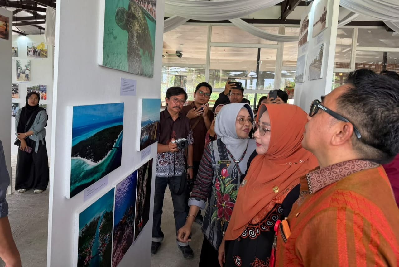 Bupati Berau, Sri Juniarsih Mas, mengamati karya fotografi yang menampilkan keindahan alam dan potensi wisata Berau dalam pameran 73 Tahun Berau dalam Gambar di Story Mount Caffe. (Foto: Nur Hidayah/Pusaranmedia.com)