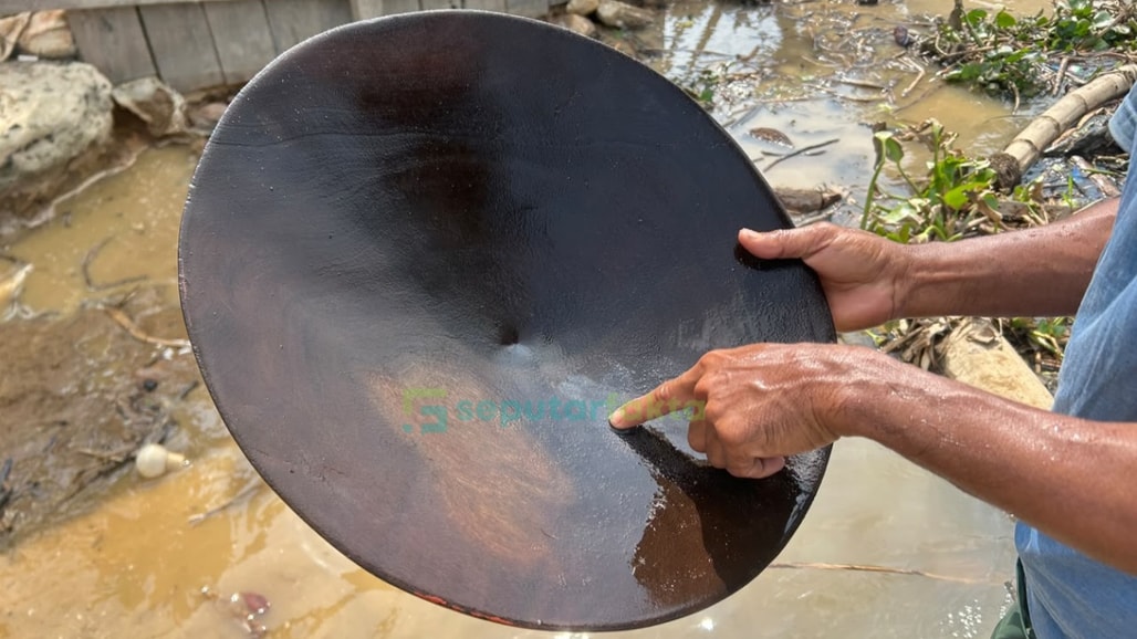 Warga menunjukkan hasil dulangan, berupa partikel kuning berkilau yang diyakini sebagai emas. (Foto: Agus Saputra/Seputarfakta.com)