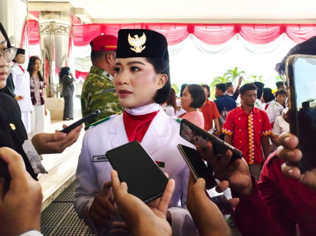 Harnawati membawa bendera Merah Putih dalam upacara detik-detik Proklamasi HUT ke-81 RI di Lapangan Kantor Bupati Kutim, (Foto:Lisda/seputarfakta.com)